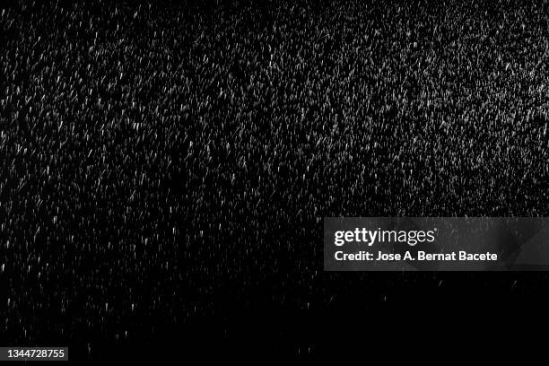 sprayed water drops floating on a black background. - espray aerosol fotografías e imágenes de stock