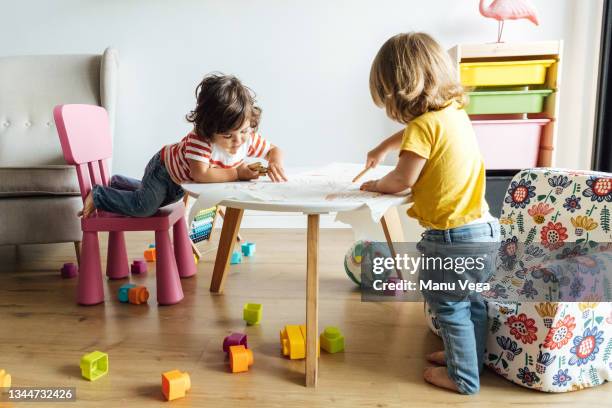 side view preschool kids playing drawing in modern table with small armchair while spending time together in playroom of modern kindergarten - lekrum bildbanksfoton och bilder