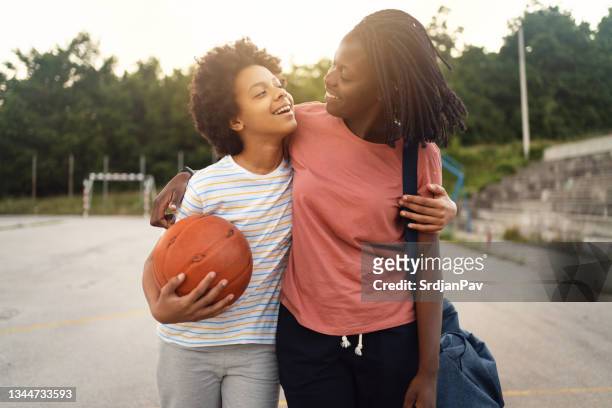 proud mother of black ethnicity, picking up her teenage daughter from her basketball practise - parent stock pictures, royalty-free photos & images
