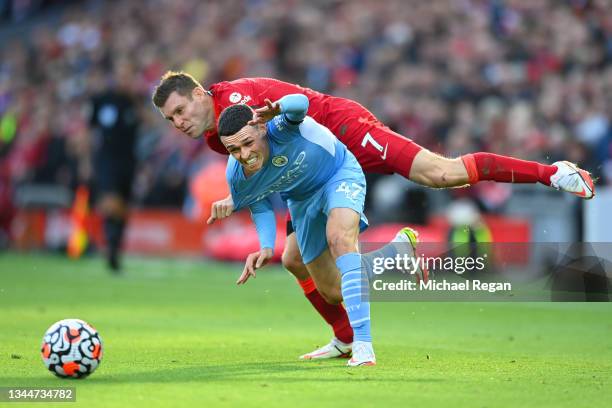 James Milner of Liverpool fouls Phil Foden of Manchester City for which he receives a yellow card during the Premier League match between Liverpool...