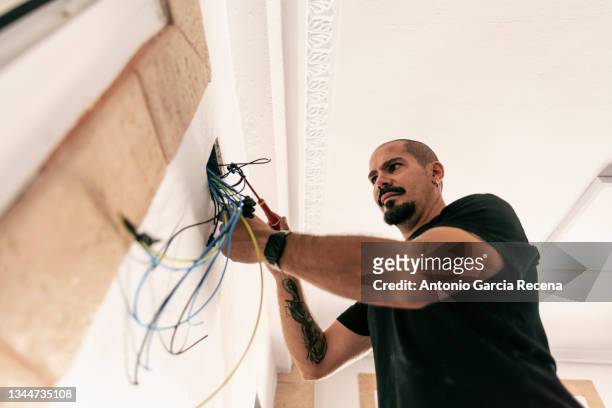 electrician prepares the installation of electrical wiring in the renovation of a home - schraubenzieher stock-fotos und bilder
