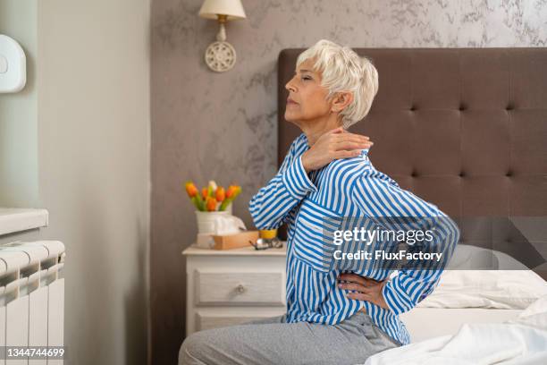 senior woman waking up with the backache pain, in the morning - back pain bed stock pictures, royalty-free photos & images