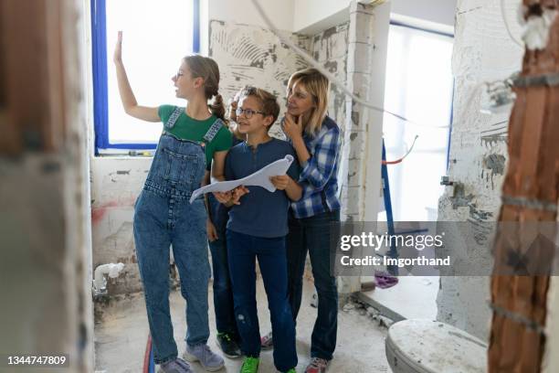 la famille discute des plans pendant la rénovation de la maison - teenager alter photos et images de collection