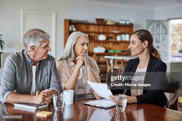 mature couple with financial advisor at home - retirement financial planning stock pictures, royalty-free photos & images