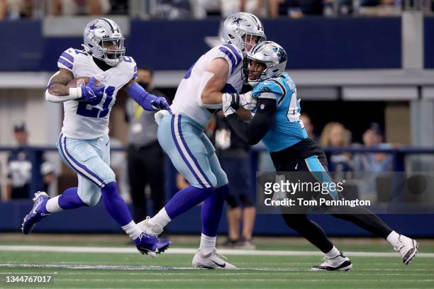 Running back Ezekiel Elliott of the Dallas Cowboys carries the ball against defensive tackle Derrick Brown of the Carolina Panthers in the first half...