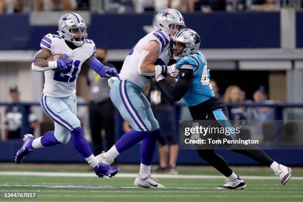 Running back Ezekiel Elliott of the Dallas Cowboys carries the ball against defensive tackle Derrick Brown of the Carolina Panthers in the first half...