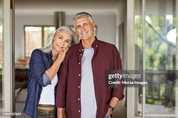 smiling mature couple at home during lockdown - quarantaine stockfoto's en -beelden