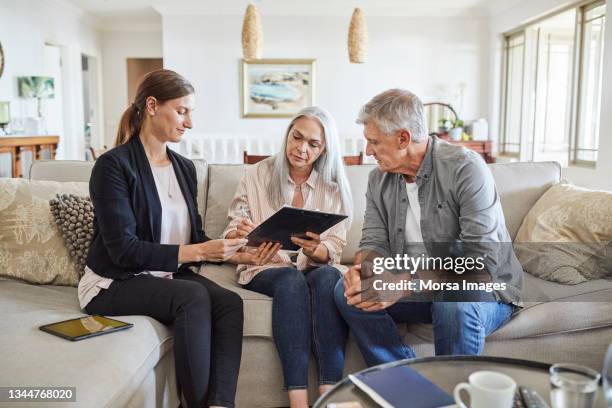 mature couple with insurance agent at home - financial planning stock pictures, royalty-free photos & images