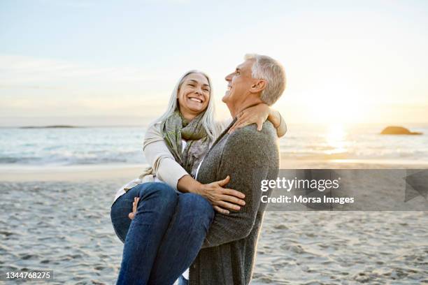 happy mature couple at beach during vacation - 50 59 years stock pictures, royalty-free photos & images