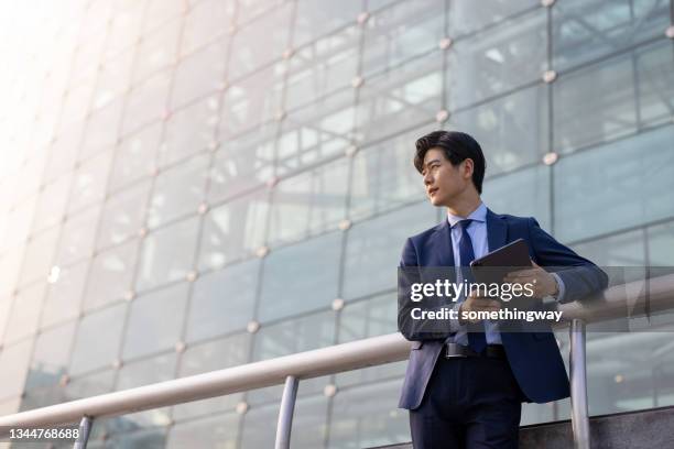 hombres de negocios asiáticos que usan tabletas - asia fotografías e imágenes de stock