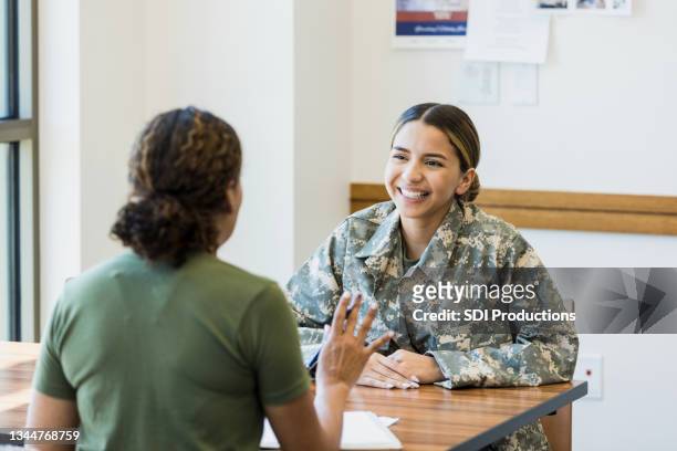 若い女性兵士は、パフォーマンスレビュー中に緊張して笑顔 - 退役軍人 ストックフォトと画像