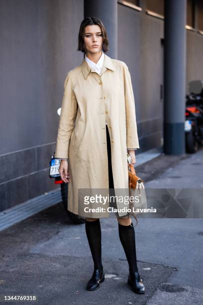 Vivienne Rohner, wearing a beige trench coat, poses ahead of the Missoni fashion show during the Milan Fashion Week - Spring / Summer 2022 on...