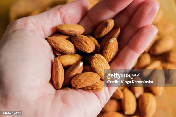 handful of almonds - eating nuts stock-fotos und bilder