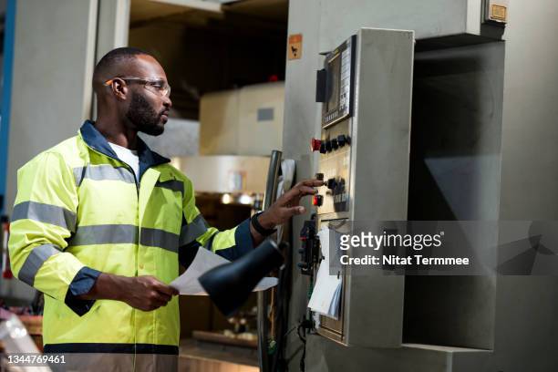 analysis and reduction of the waste in the machining process. african machining milling operator input milling cutting parameters on switchboard panel in a production line shopfloor. - regular guy stock pictures, royalty-free photos & images