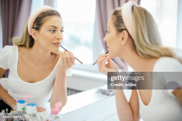 makeup artist applying make up at home - lip liner stock pictures, royalty-free photos & images