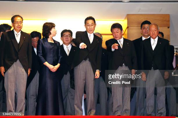 Newly elected Prime Minister Fumio Kishida and Foreign Minister Toshimitsu Motegi point at the spot for a photo session with the cabinet members at...