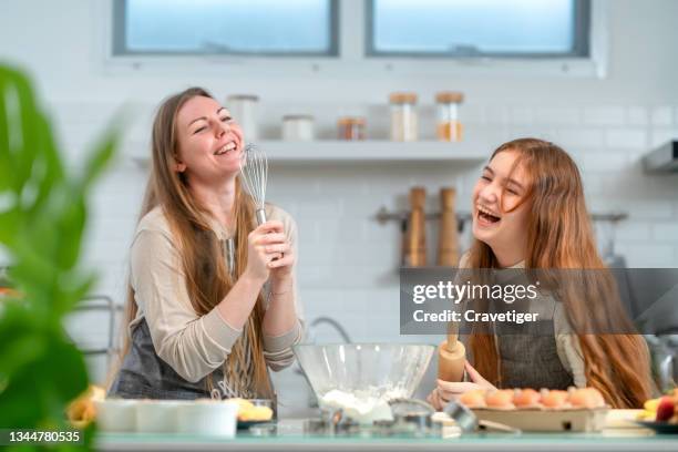 caucasian family have fun cooking baking cake or cookie in the kitchen together, happy smiling daughter enjoy playing and sing a song together while doing bakery at home. - best song stock pictures, royalty-free photos & images