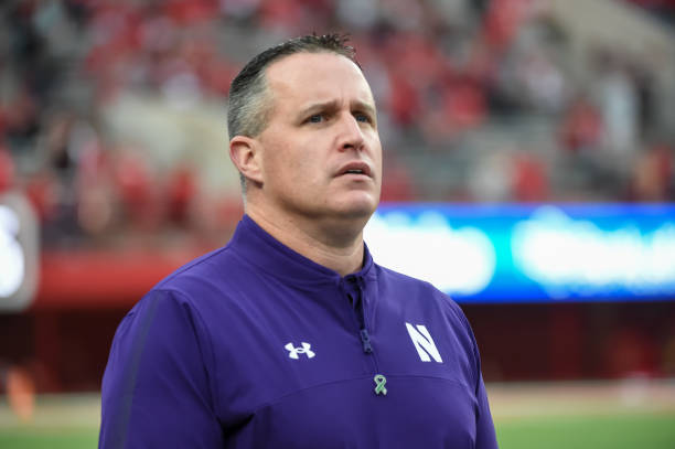 Head coach Pat Fitzgerald of the Northwestern Wildcats watches the team warm up before the game against the Nebraska Cornhuskers at Memorial Stadium...