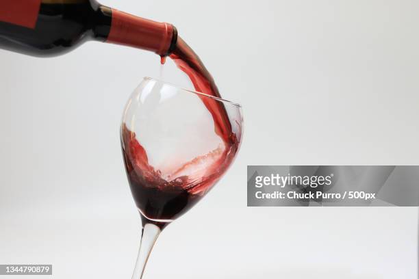 close-up of red wine pouring in glass against gray background,bradenton,florida,united states,usa - portwein stock-fotos und bilder