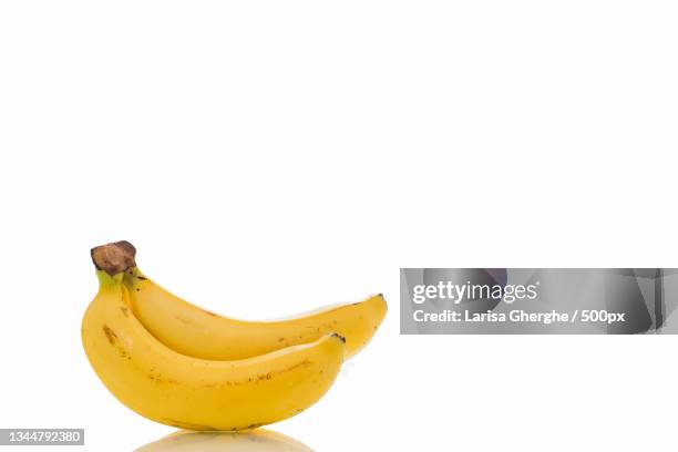 close-up of banana against white background - bio banane stock-fotos und bilder