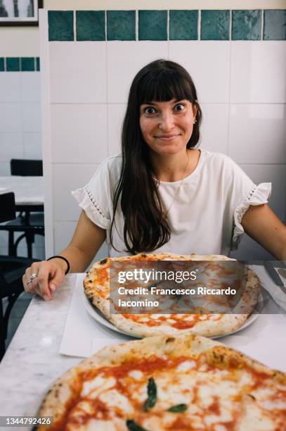 happy woman and pizza margherita in a tradigional pizzeria, naples, italy. table for two - mediterranean culture stock pictures, royalty-free photos & images