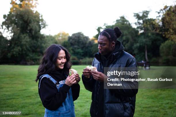 two friends eating sandwiches - female eating chili bildbanksfoton och bilder