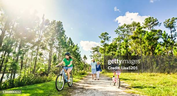 mehrgenerationenfamilie unternimmt einen naturspaziergang in idyllischer lage - biker granny stock-fotos und bilder