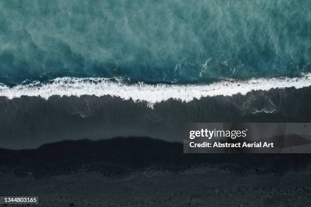 drone shot looking down on a black sand beach and ocean waves, reykjanes peninsula, iceland - volcanic rock stock pictures, royalty-free photos & images