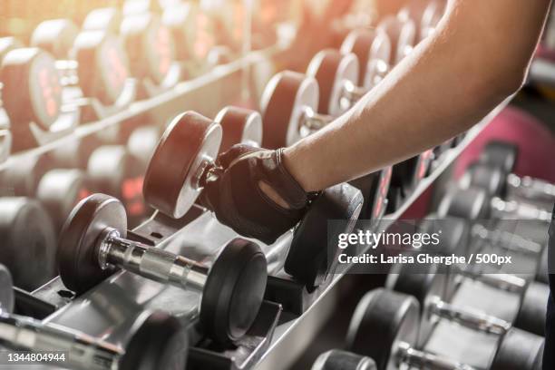 close-up of dumbbells on rack at gym - zwaar stockfoto's en -beelden