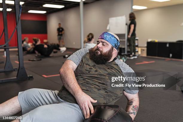 man doing abdominal workout at the gym - community effort stock pictures, royalty-free photos & images