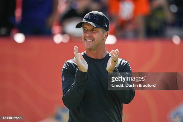 Head coach John Harbaugh of the Baltimore Ravens walks onto the field before a game against the Denver Broncos at Empower Field at Mile High on...