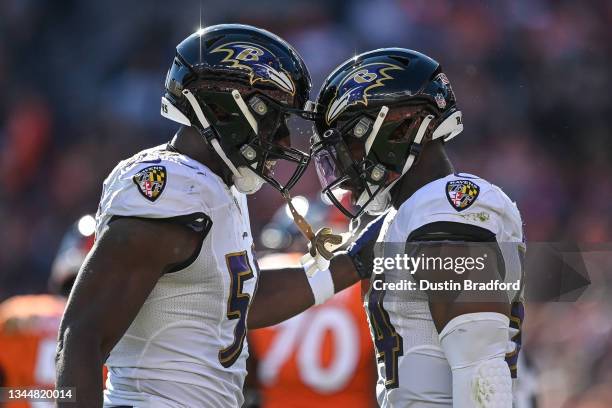 Justin Houston and Tyus Bowser of the Baltimore Ravens celebrate after a second quarter sack against the Denver Broncos at Empower Field at Mile High...