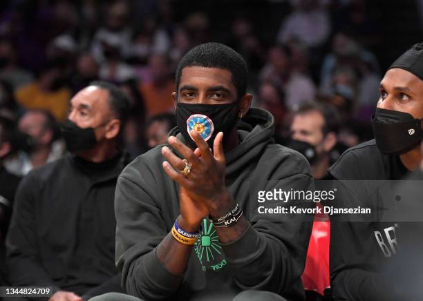 Kyrie Irving of the Brooklyn Nets cheers from the bench during a preseason game against the Los Angeles Lakers at Staples Center on October 3, 2021...