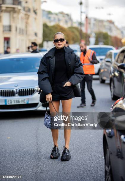 Caroline Daur seen wearing black shorts, turtleneck, down feather jacket, Prada bag, sunglasses outside Giambattista Valli during Paris Fashion Week...