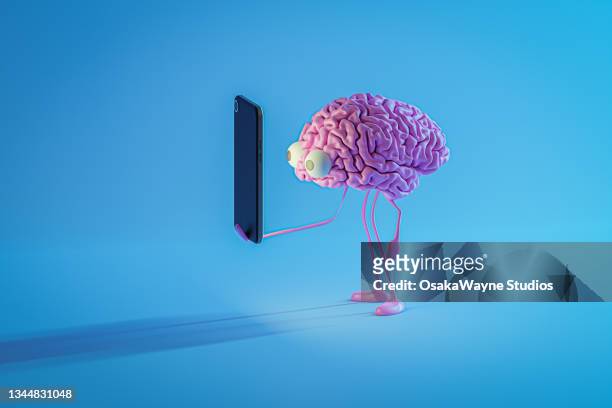 pink brain looking at smartphone screen - brain cells stock-fotos und bilder
