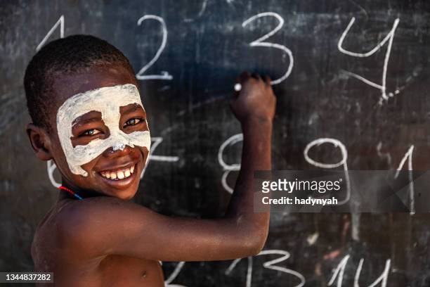 afrikanischer junge während des mathematikunterrichts, arbore-stamm, omo-tal, äthiopien - schwarz ethnischer begriff stock-fotos und bilder