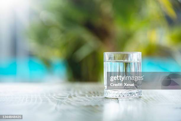 clean water in small glass on table - mini bar stockfoto's en -beelden