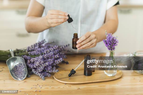 woman hands holding pipette of essential lavender oil. - perfumería fotografías e imágenes de stock