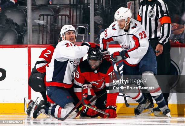 Garnet Hathaway and Nic Dowd of the Washington Capitals combine to hit P.K. Subban of the New Jersey Devils during the second period in a preseason...