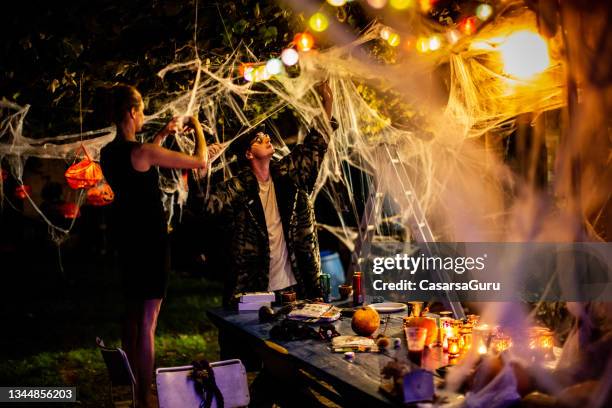 friends arranging halloween party decorations in the backyard - halloween party stock pictures, royalty-free photos & images