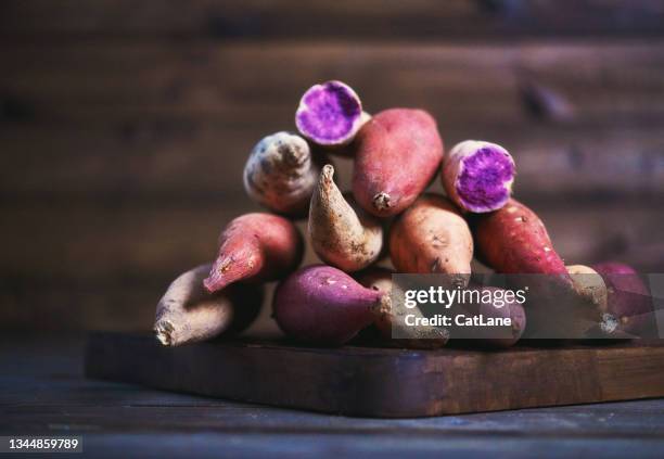 collection of sweet potato varieties on rustic chopping board - farm to table stock pictures, royalty-free photos & images