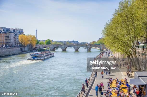 la barca turistica sul ponte sulla senna e sulla torre eiffel a parigi, in francia - river seine foto e immagini stock