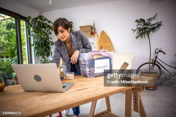 voluntário em home office preparando roupas para a doação - organização sem fins lucrativos - fotografias e filmes do acervo