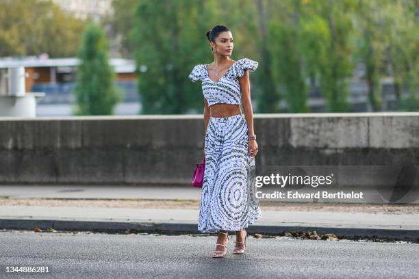 Jessica Verratti wears gold earrings, gold chain pendant belt - necklaces, a white embossed lace with green foliage print patterns V-neck / puffy...