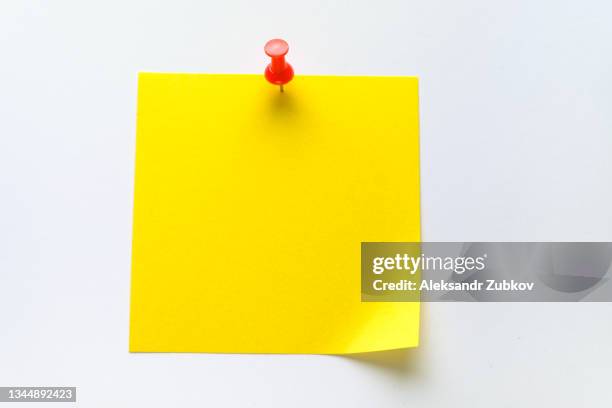 blank clean yellow sticky sticker on a white background for reminding information, attached with a paper clip. space for text. - punaise stockfoto's en -beelden