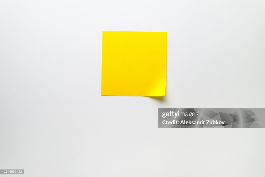 Blank Clean Yellow Sticky Sticker On White Background For Informational Reminder. A piece of paper. Space For Text.