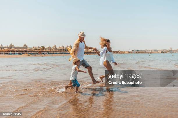 familienlauf und planschen am strand - egypt stock-fotos und bilder