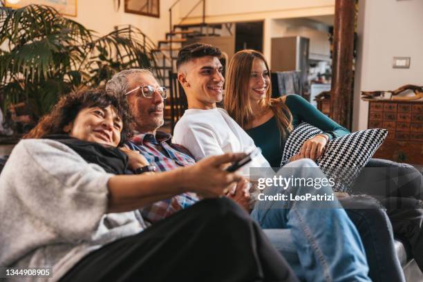 happy family relaxing and watching tv together - broadcasting house stock pictures, royalty-free photos & images