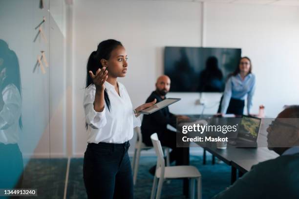 female entrepreneur giving presentation to colleagues in office - marketing meeting stock pictures, royalty-free photos & images