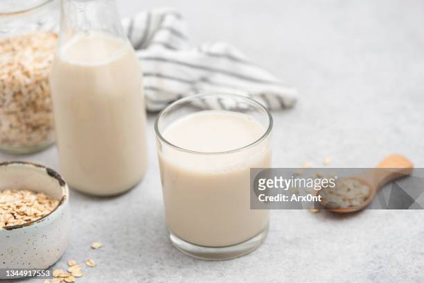 vegan oat milk in glass - glass of milk stock pictures, royalty-free photos & images